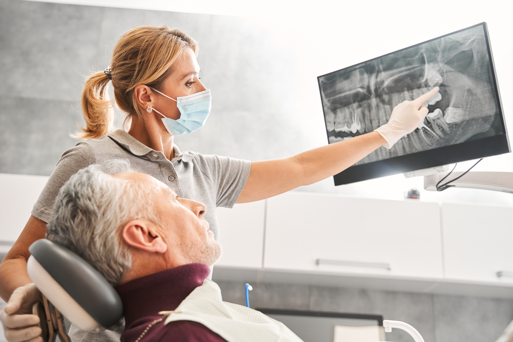 An illustration defining dental implants with a cutaway view of the jawbone showing an implant, abutment, and crown. The text on the image should read, "Definition of Implants: A Permanent Solution for Missing Teeth."